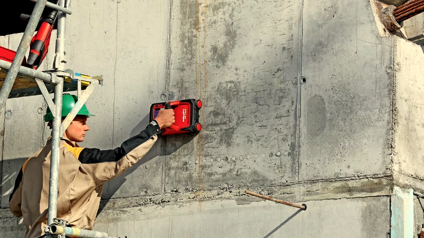Surveyor scanning a concrete column on a construction site with Hilti ground-penetrating radar