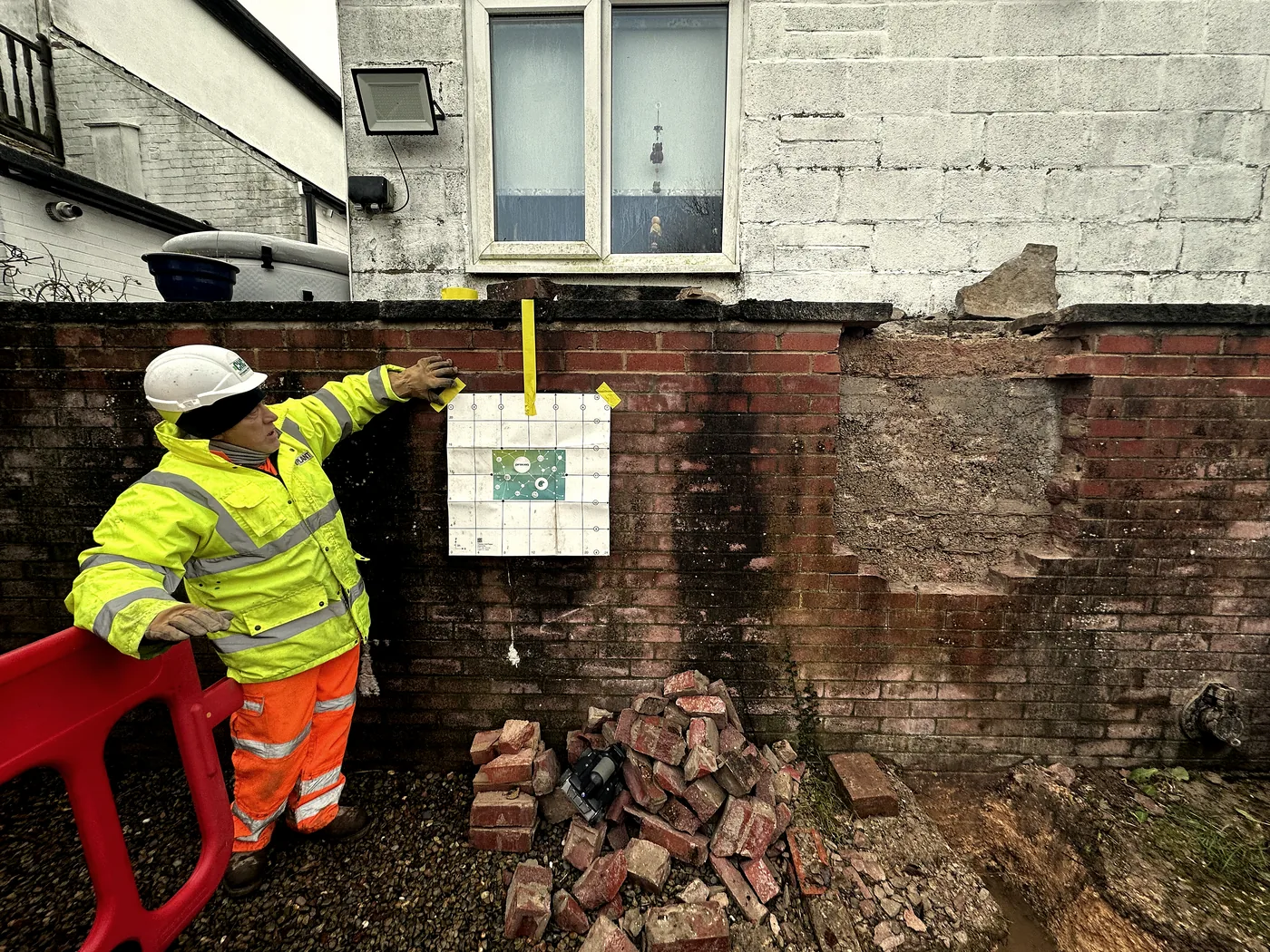 Operative scanning a brick wall with ground-penetrating radar before structural works